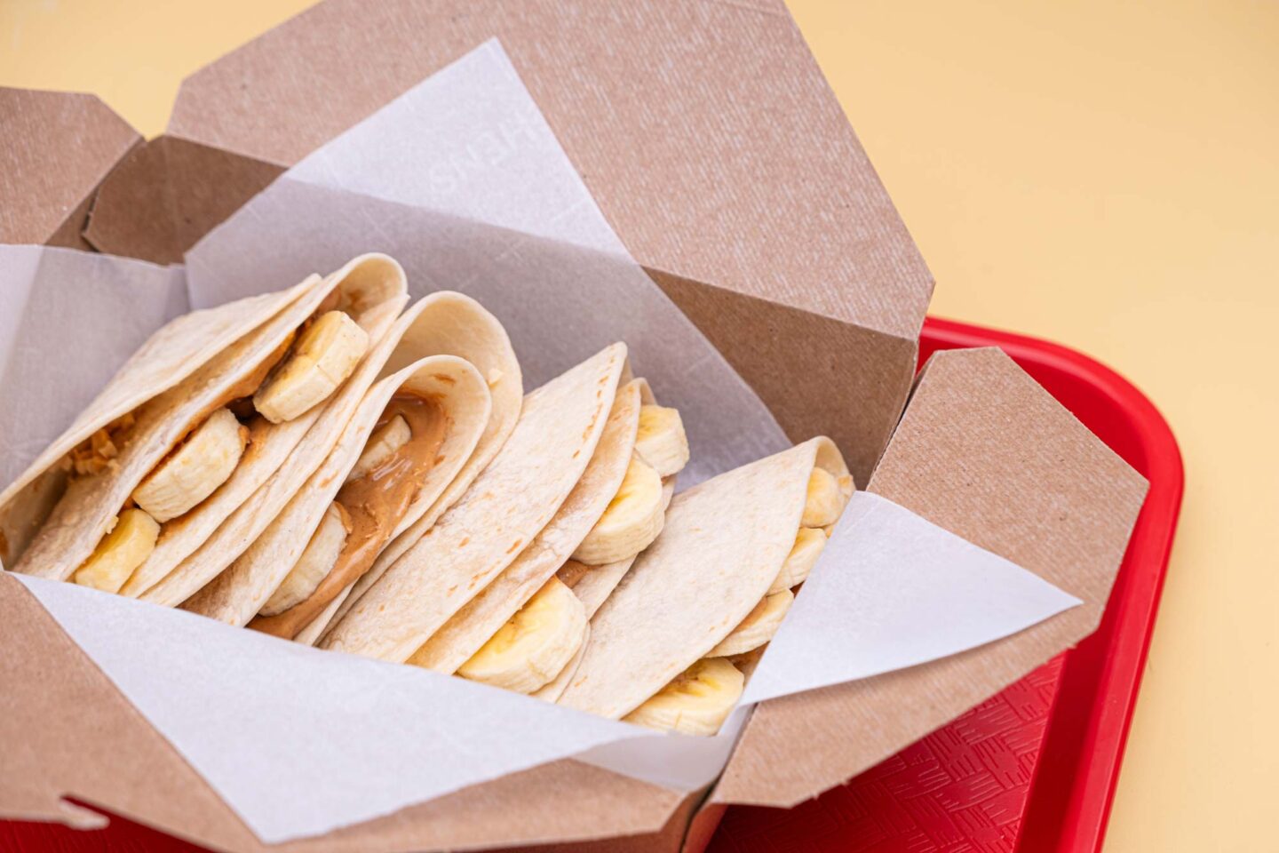 A delighful dish featuring a warm tortilla filled with creamy peanut butter, sliced bananas and a drizzle of honey.
