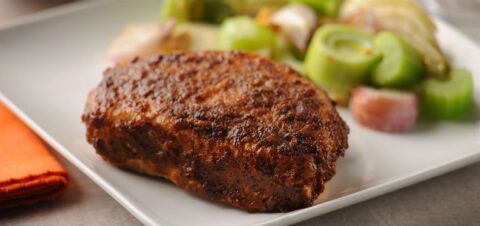 a portion of pork chop with vegetables.
