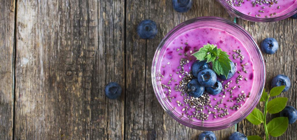 a glass of blueberry smoothie topped with chia seeds.