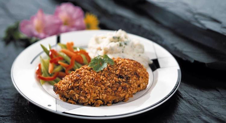 cooked chicken breast coated with glazed peanut chunks.