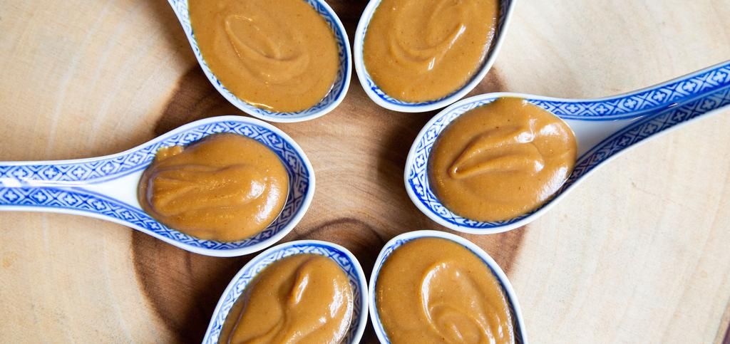 six spoons filled with peanut butter forming a circle.