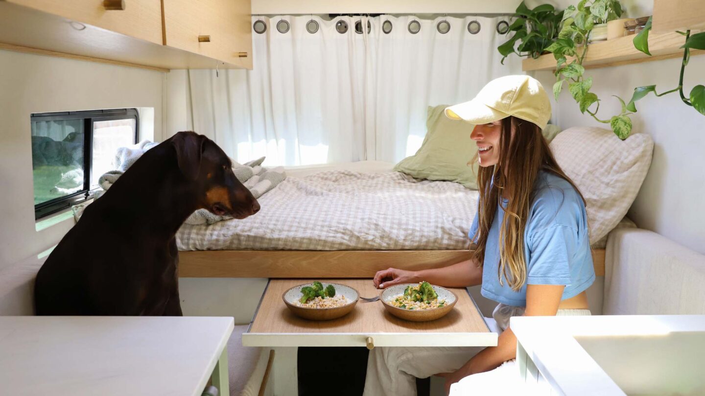 girl sharing dinner with her dog