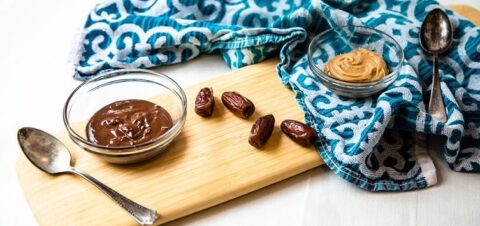 a bowl full of chocolate cream next to a peanut butter one.