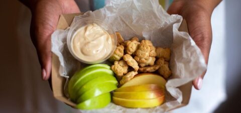 a paper box full of apple slices