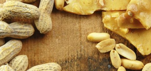 a wooden table topped with peanuts unshelled